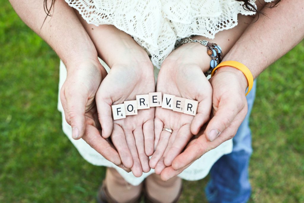 Couple holding forever scrabble tiles in their hands