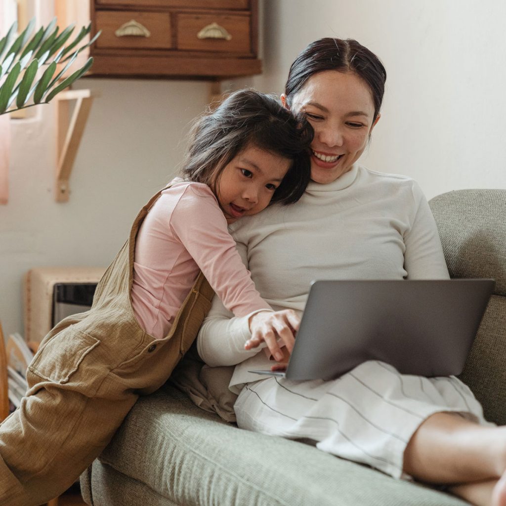Single Mom Smiling at Laptop with her Daughter